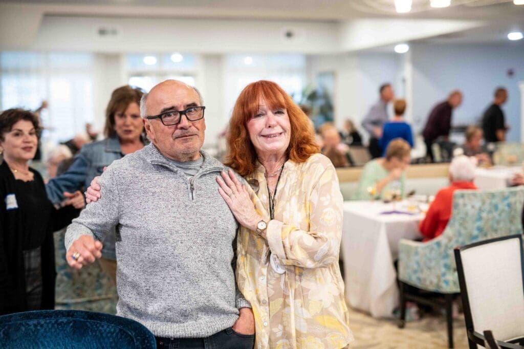 Joyful seniors engage at a vibrant gathering, showcasing warmth and connection amidst an elegant dining setting.