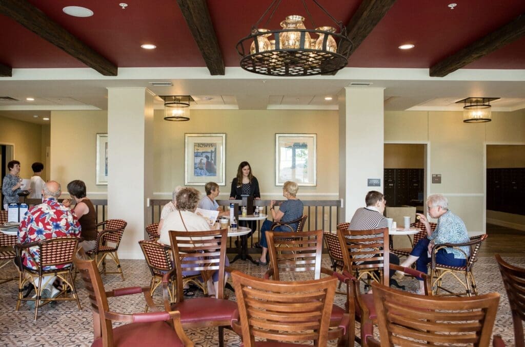 Dining-Room-2048x1356 - Grace Management Seniors engage joyfully at a stylish communal dining area, enjoying conversation and refreshments in an inviting atmosphere.