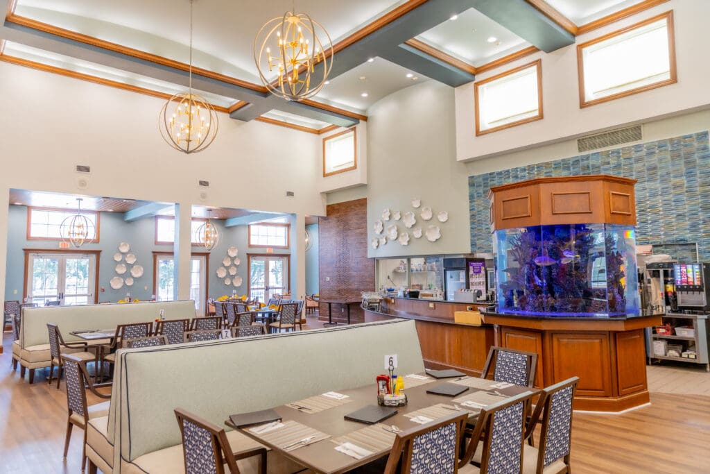 Bright dining area with elegant furnishings, stylish decor, and an aquarium, inviting a vibrant social atmosphere.
