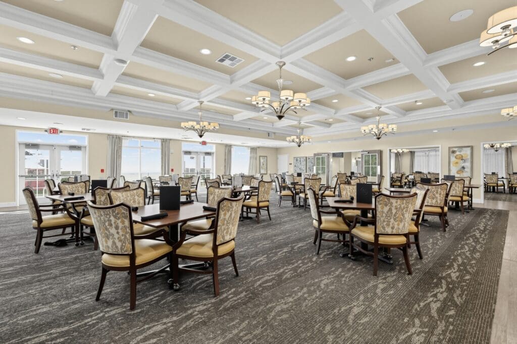 Elegant dining room featuring stylish furniture, abundant natural light, and a serene atmosphere for senior residents.