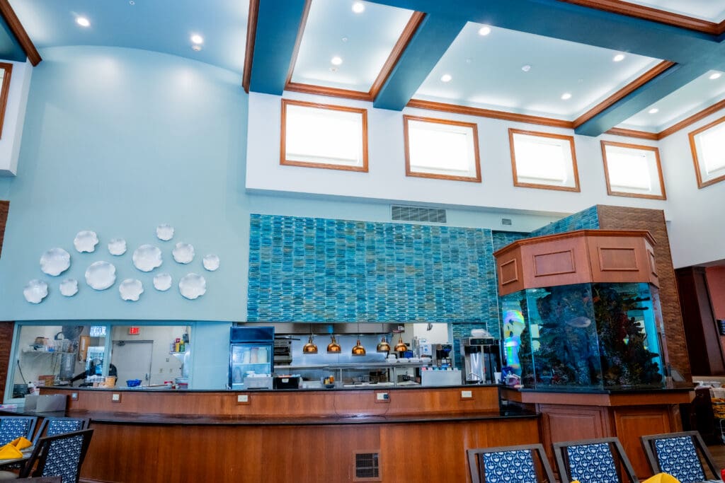 Bright, inviting cafe interior featuring chic decor, a vibrant aquarium, and a modern dining area for seniors' enjoyment.
