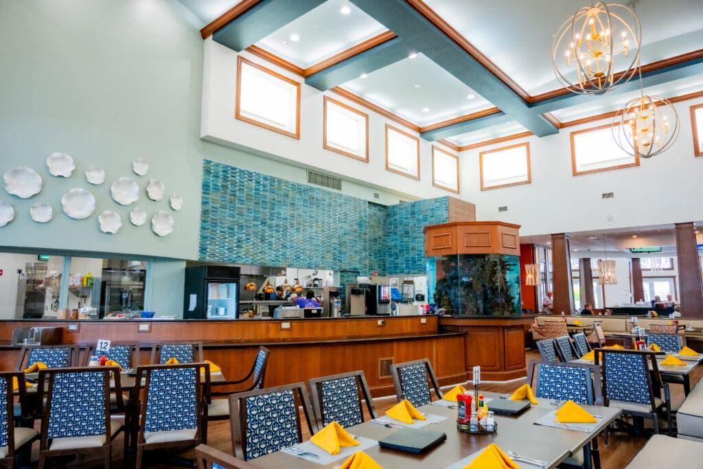 Elegant dining area featuring upscale decor, vibrant atmosphere, and compassionate staff preparing meals in an open kitchen.