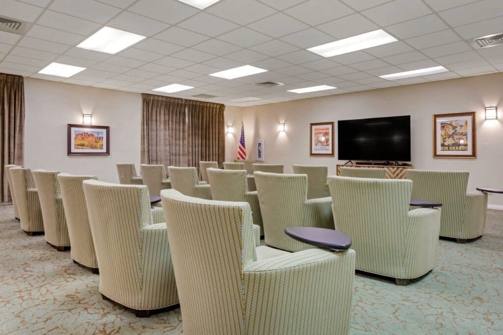 Final-Selects-303A5297-Large - Grace Management Upscale theater-style seating arranged in a bright, inviting lounge with warm lighting and decorative artwork.