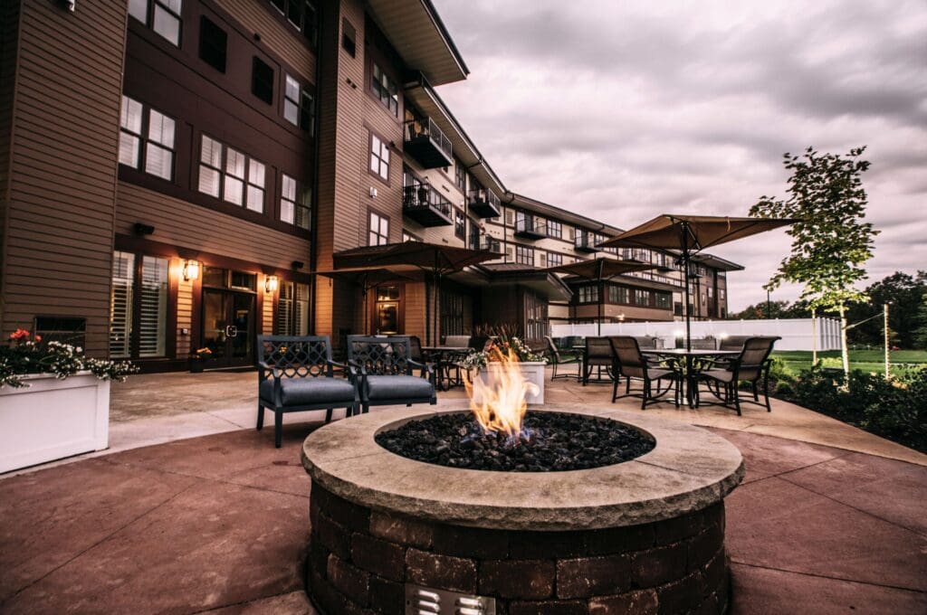 Fire-Pit-2-scaled - Grace Management Inviting outdoor patio featuring a fire pit, comfortable seating, and beautifully landscaped surroundings at a senior living community.