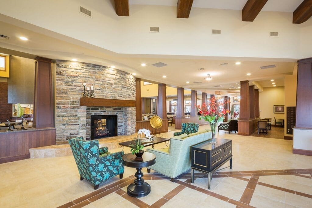 Elegant lounge area featuring stylish seating, a warm fireplace, and vibrant decor, promoting a welcoming, upscale atmosphere.