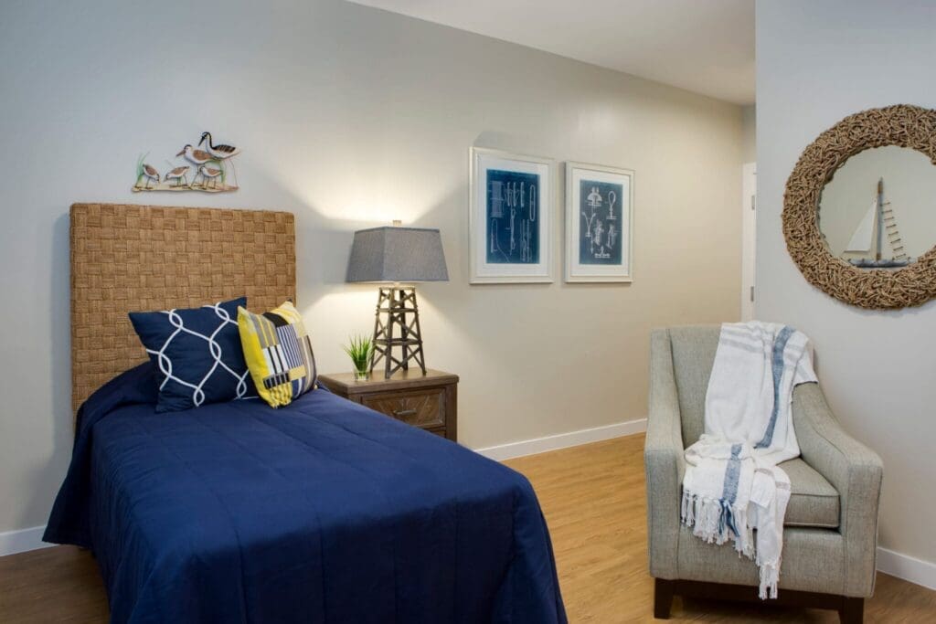 Heritage-Oaks1826-1-2048x1366 - Grace Management Cozy, elegantly designed bedroom featuring a navy bedspread, stylish decor, and warm lighting for a welcoming atmosphere.