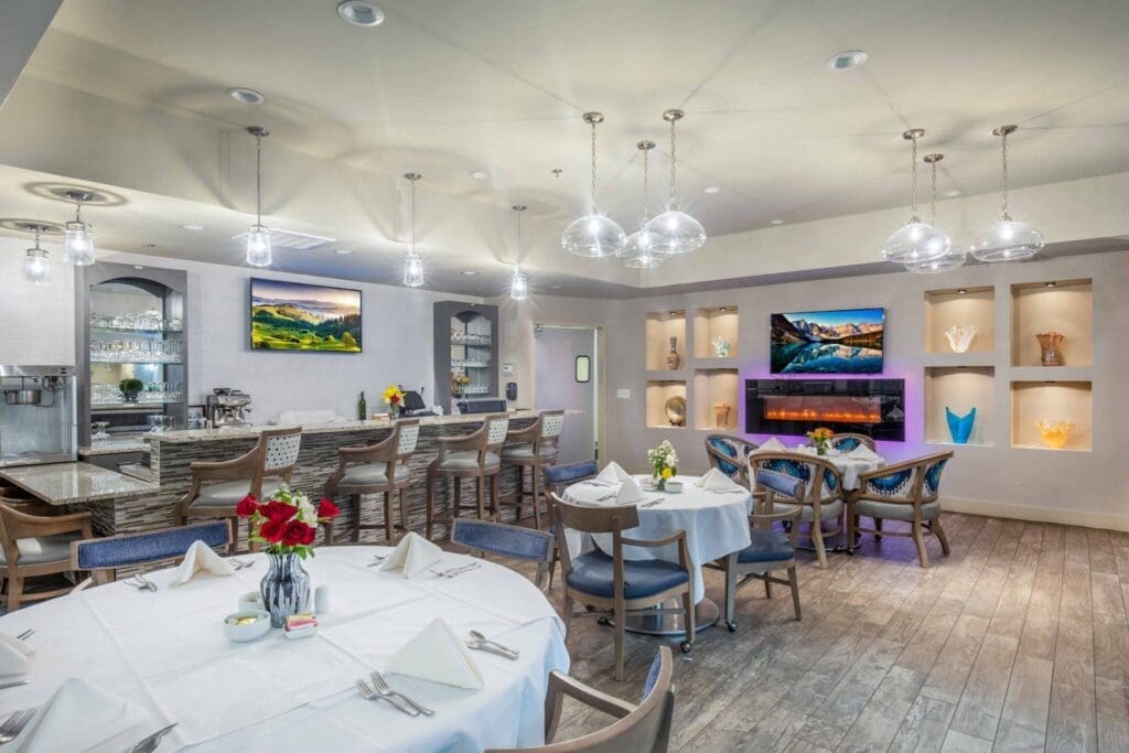 Elegant dining area featuring polished tables, vibrant floral arrangements, and upscale decor with a cozy ambiance.