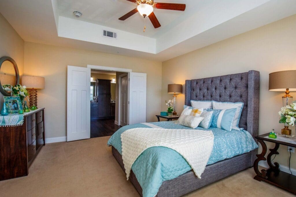 Elegant bedroom featuring a plush bed, tasteful decor, and abundant natural light for a vibrant, upscale living experience.