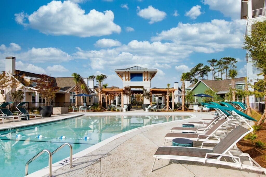 IL-Pool-4-2048x1365 - Grace Management Inviting pool area featuring modern lounge chairs, upscale amenities, and vibrant surroundings under a bright blue sky.