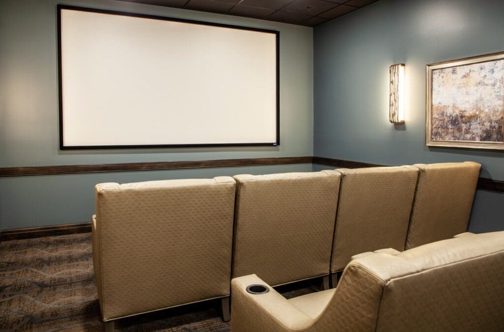 IMG_9588-HDR-Large - Grace Management A cozy theater room featuring plush seating arranged in front of a large screen, perfect for community film nights.