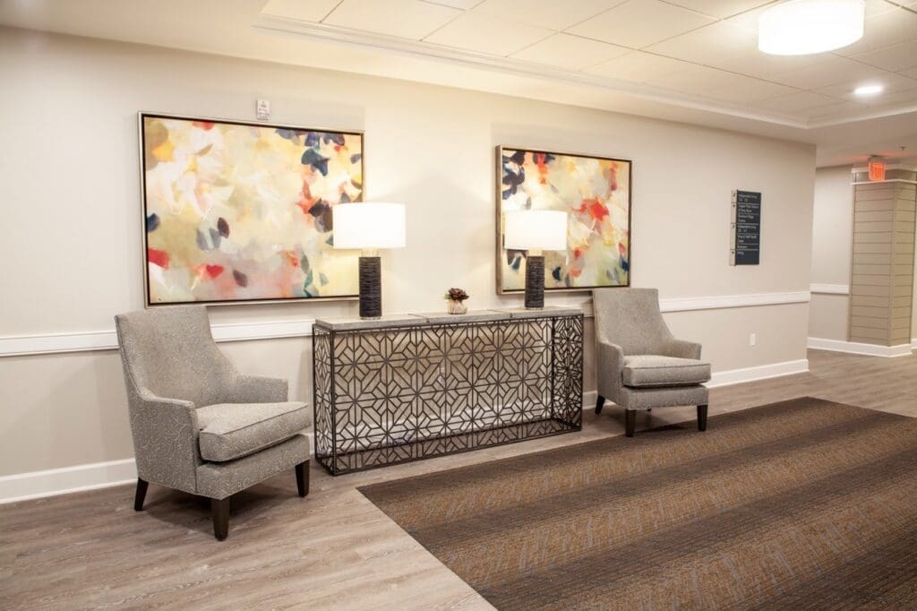 IMG_9593-HDR-Large - Grace Management Stylish lobby featuring elegant chairs, abstract art, and accent lighting, embodying a warm, inviting atmosphere.