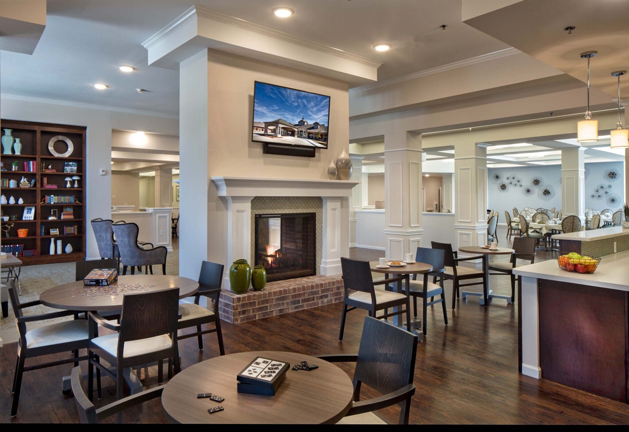 Cafe tables are set near a fire place in the community bistro at Twin Rivers, an assisted living and memory care community near Garland, TX.