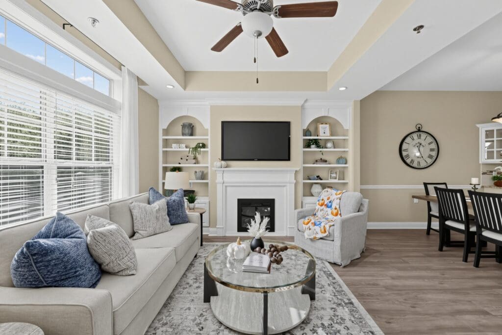 Inviting living room featuring a cozy sofa, stylish decor, a wall-mounted TV, and a dining area with elegant furnishings.