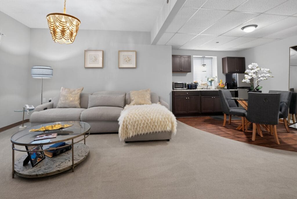 Spacious, elegantly furnished living area with a cozy sofa, modern dining table, and upscale kitchen amenities.