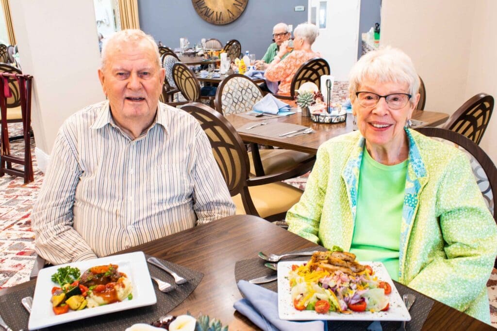 Seniors enjoying a vibrant meal in an upscale dining area, with colorful dishes and cheerful ambiance surrounding them.