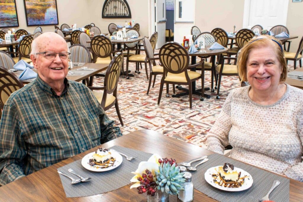 Seniors enjoying dessert together in an upscale dining area, surrounded by elegant tables and vibrant decor.