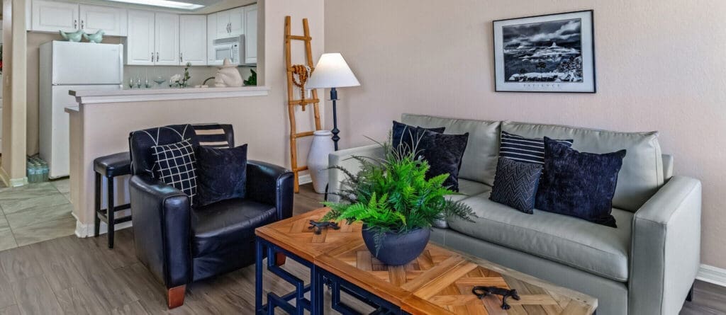 MG_4419-e1687984561454 - Grace Management Stylish living room featuring plush seating, elegant decor, and vibrant greenery, creating a warm, inviting atmosphere.