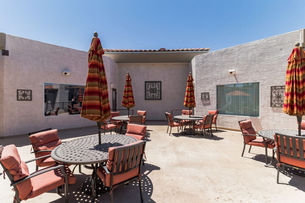 MG_4506-11205341 - Grace Management Elegant outdoor patio with vibrant umbrellas and cozy seating, inviting residents to enjoy a sunny and comfortable space.