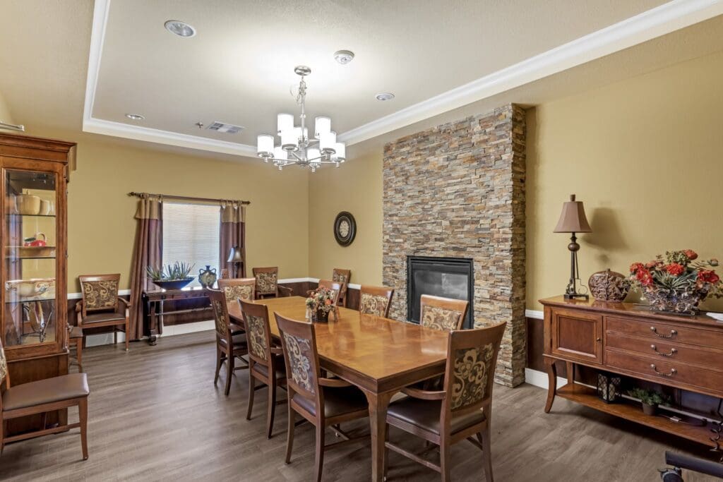Elegant dining room featuring a rustic stone fireplace, large table, and stylish decor, promoting communal gatherings.
