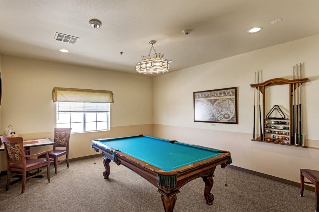 Inviting game room featuring a polished billiards table, elegant lighting, and comfortable seating, fostering engaging social interaction.