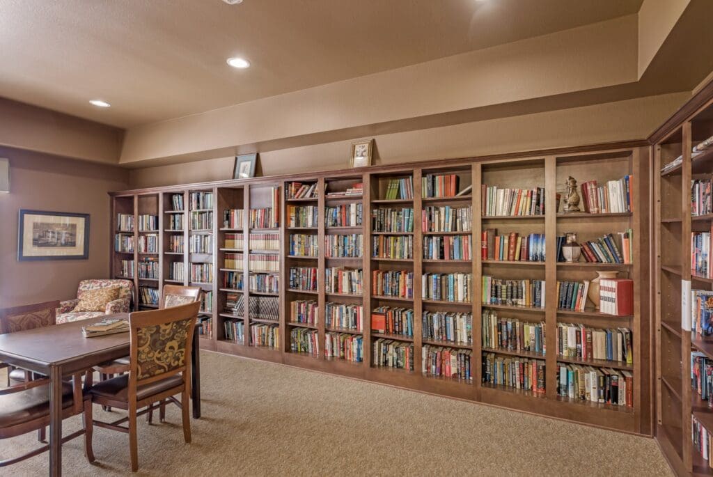 Warm and inviting library with rich wooden bookshelves, a cozy reading chair, and a table for engaging discussions.