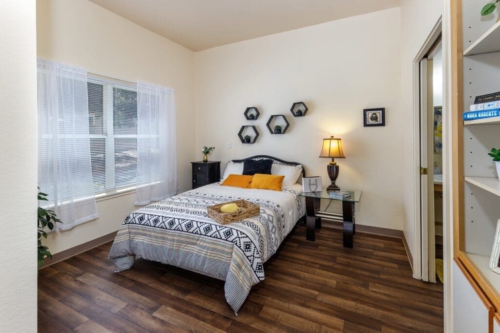 Bright, inviting bedroom with a cozy bed, elegant decor, warm lighting, and natural light streaming through the window.