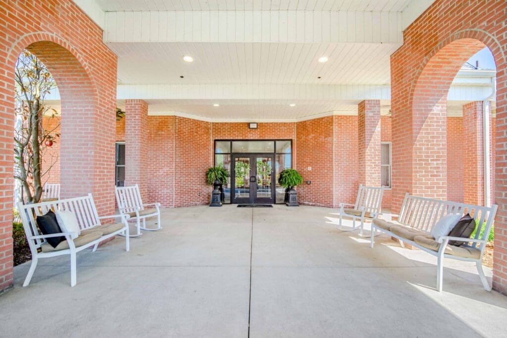 Inviting entrance with stylish wooden benches and lush greenery, showcasing a warm ambiance for residents and guests.