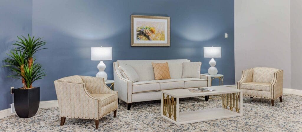 Elegant sitting area featuring a stylish sofa, armchairs, and a decorative coffee table, surrounded by modern decor.