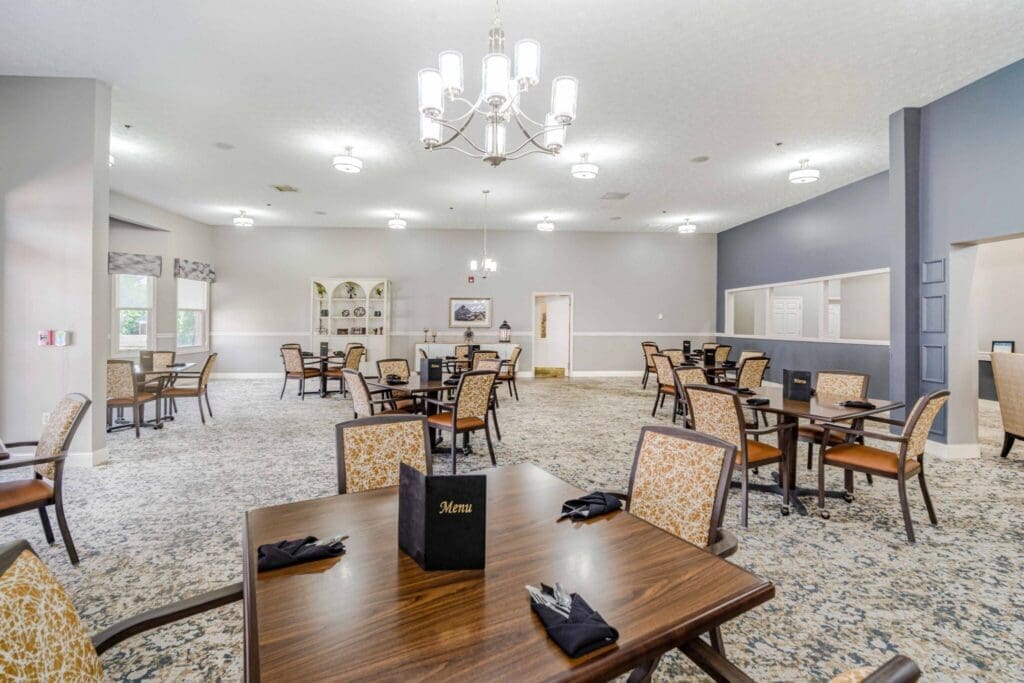 Spacious dining area featuring elegant tables, comfortable chairs, and soft lighting, inviting a vibrant community atmosphere.