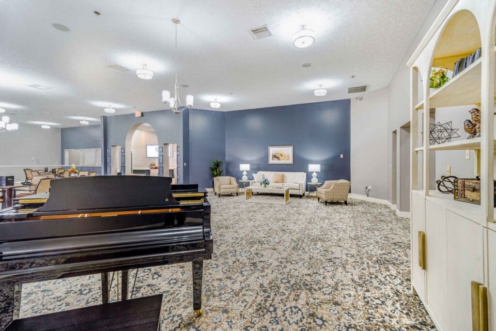 Elegant common area featuring a grand piano, comfortable seating, tasteful decor, and welcoming ambiance.