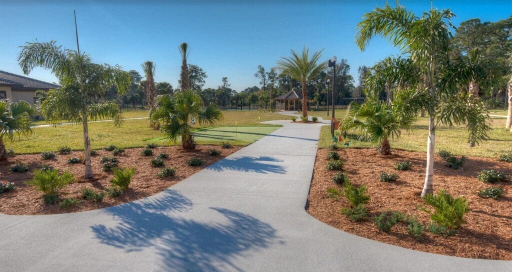 Lush landscaped pathway winding through vibrant greenery, leading to a gazebo in a serene senior living community setting.