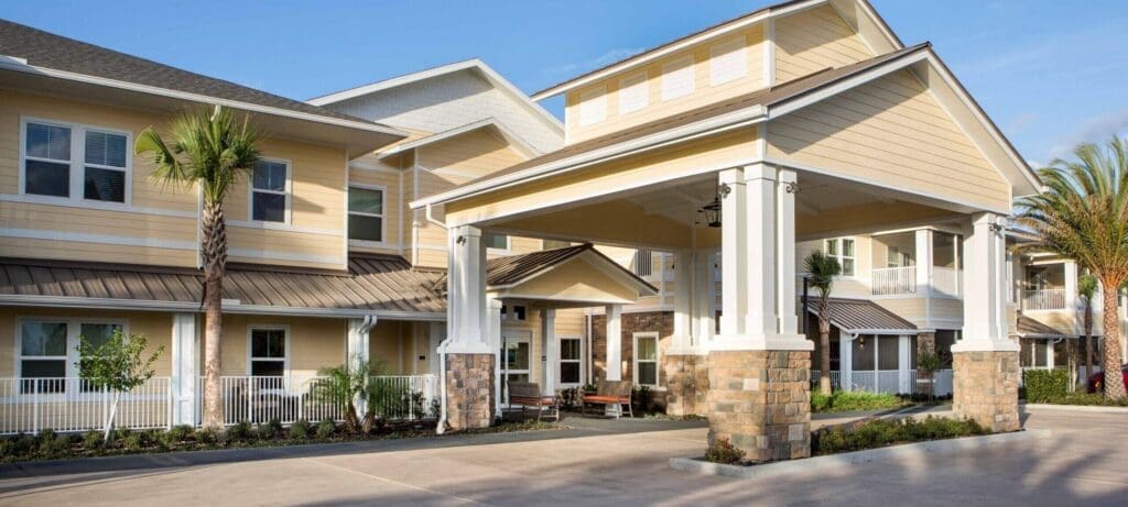 Elegant senior living community entrance featuring modern architecture, lush landscaping, and inviting outdoor spaces.