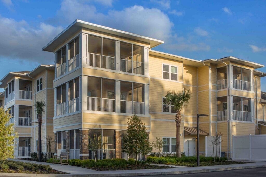 Sophisticated senior living community with modern architecture, spacious balconies, and lush landscaping.