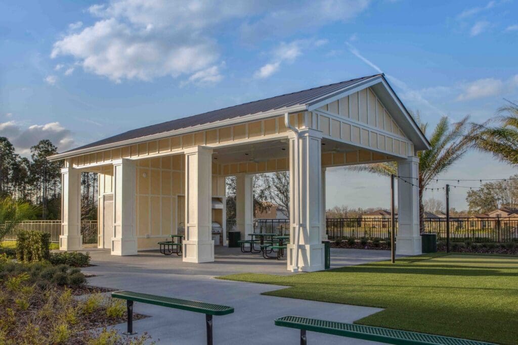 Charming outdoor pavilion with seating and lush greenery, offering an inviting space for gatherings and relaxation.