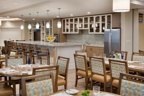 Elegant dining area featuring stylish tables, comfortable seating, and a modern kitchen, promoting a vibrant community atmosphere.