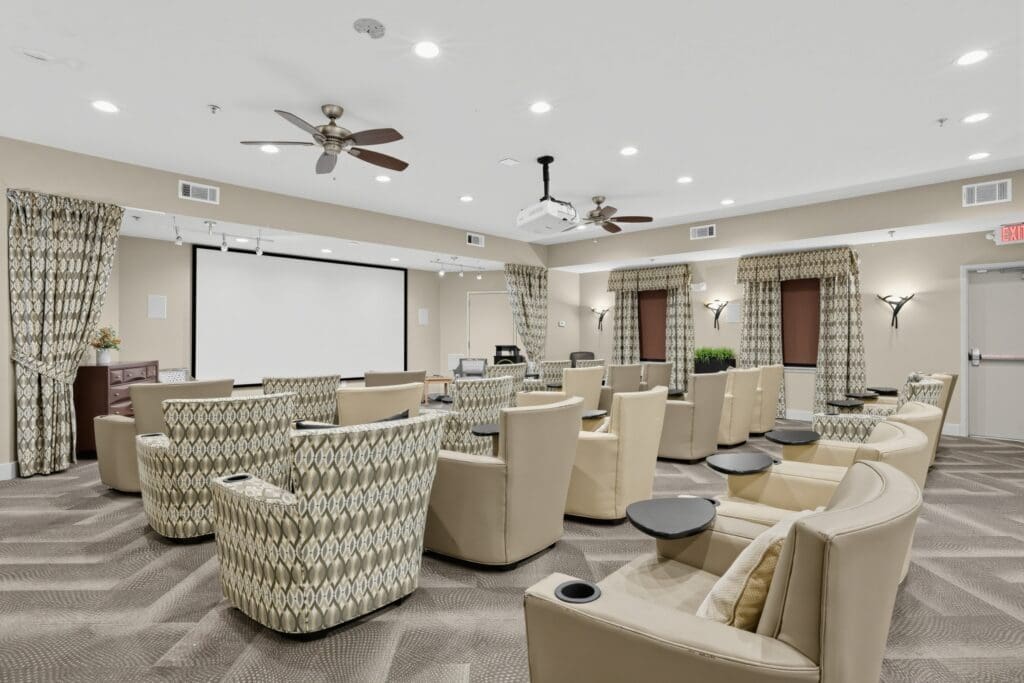 Elegant theater room featuring comfortable seating, a large screen, and upscale decor for vibrant community gatherings.