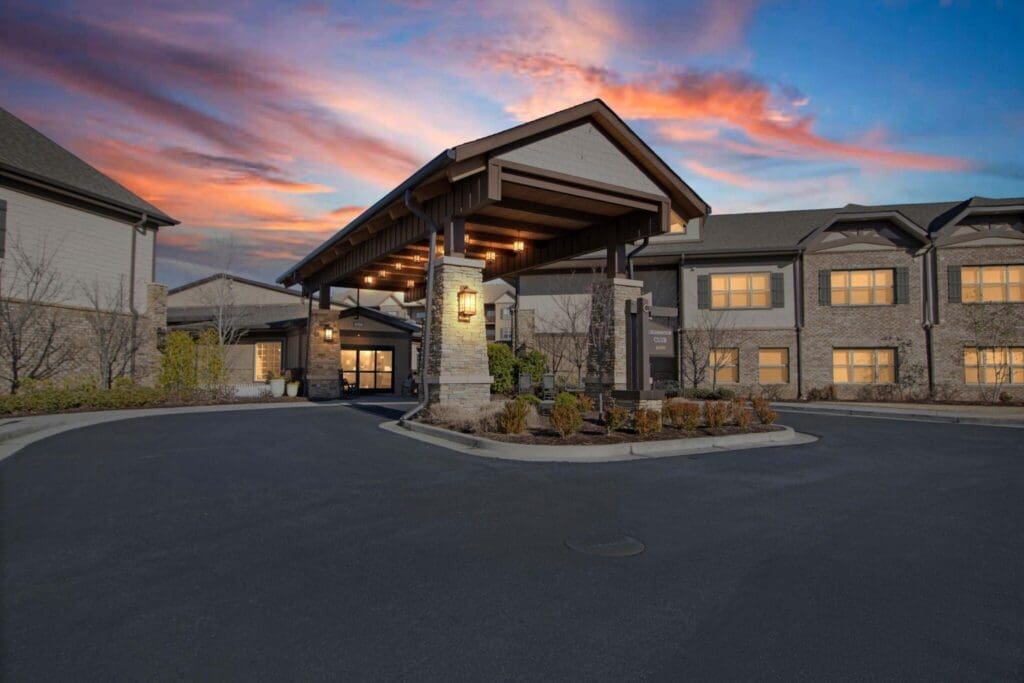 Elegant entryway of a senior living community, featuring a welcoming porte-cochère and beautifully landscaped surroundings.