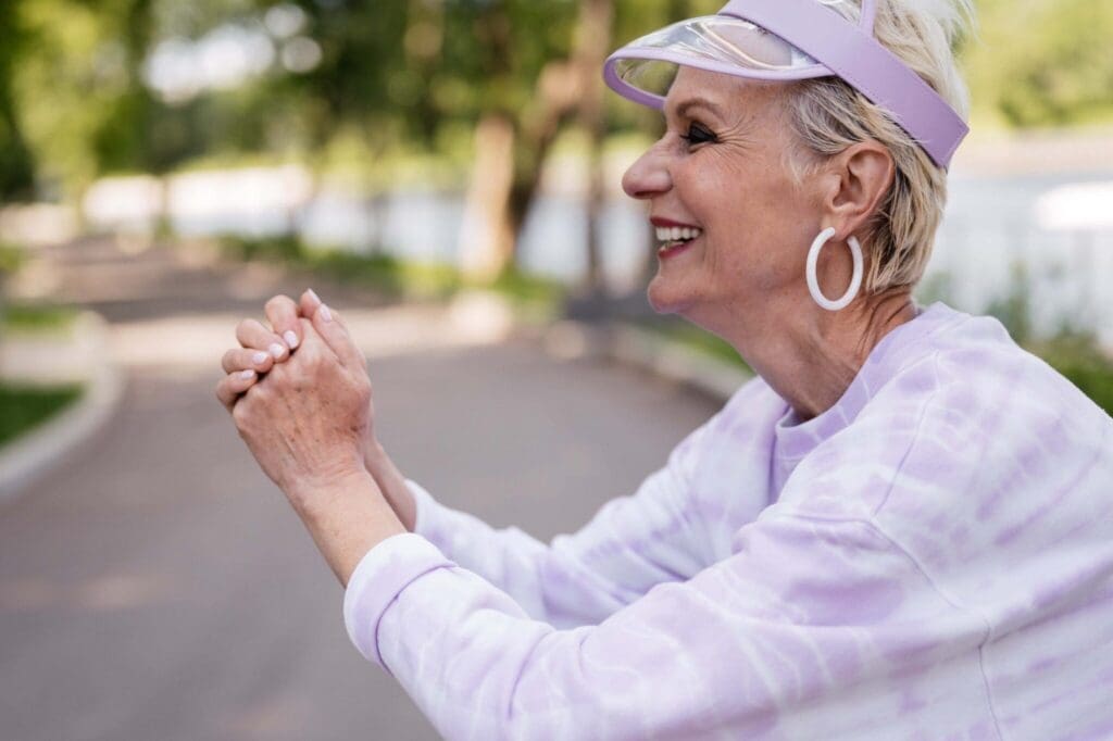 pexels-shvets-production-8417515-2048x1363 - Grace Management Senior woman in a purple visor joyfully engaging outdoors, showcasing a vibrant lifestyle in a lush, green setting.