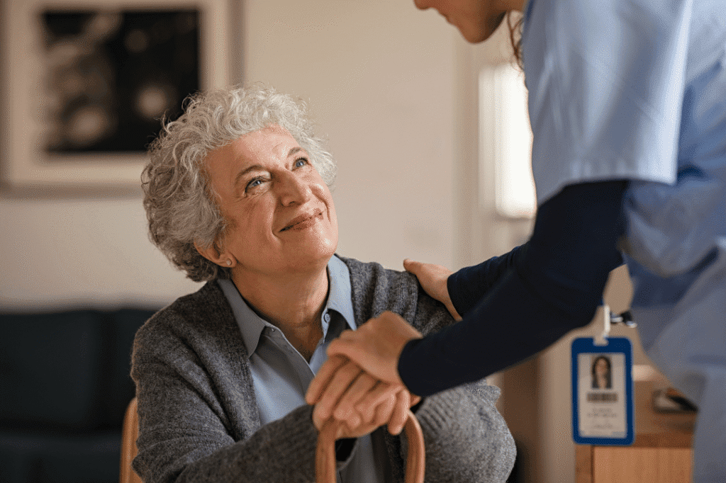A compassionate caregiver and a joyful senior share a warm moment, highlighting supportive connections in a welcoming environment.