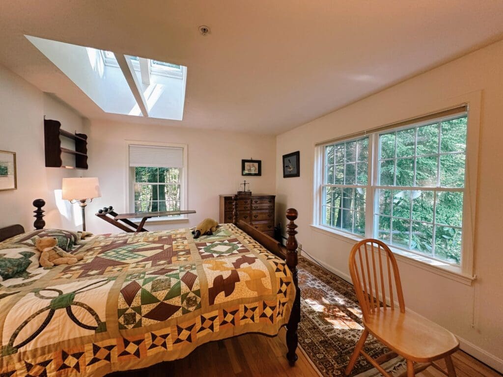 - Grace Management An interior bedroom with cozy furniture and beautiful natural light at The Highlands, a reliable assisted living option near Brunswick, Maine.