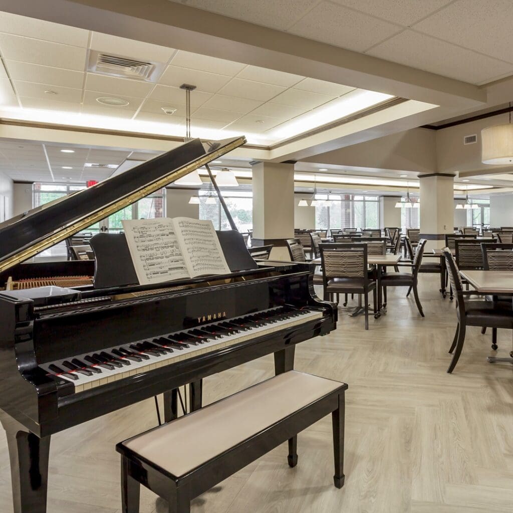 A baby grand piano sits on display in the dining room.