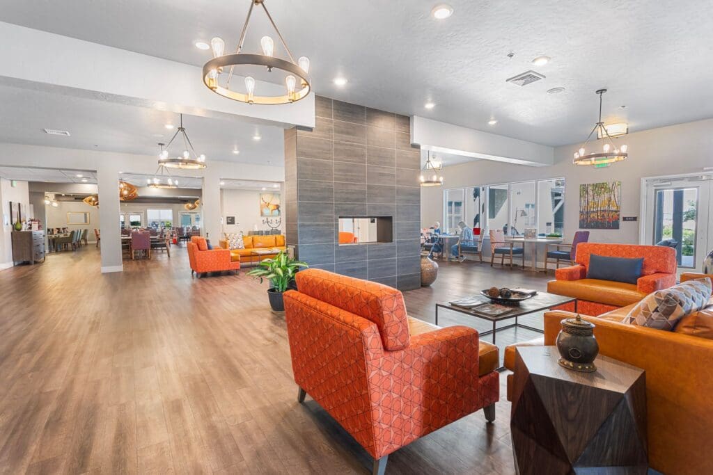 - Grace Management Interior community room at The Pointe at Meridian with comfortable chairs and a beautiful fire place.