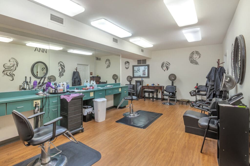 - Grace Management A beauty salon with mirrors, hair tools, and black chairs at Town Village Tulsa, a senior living community near Broken Arrow offering independent living.