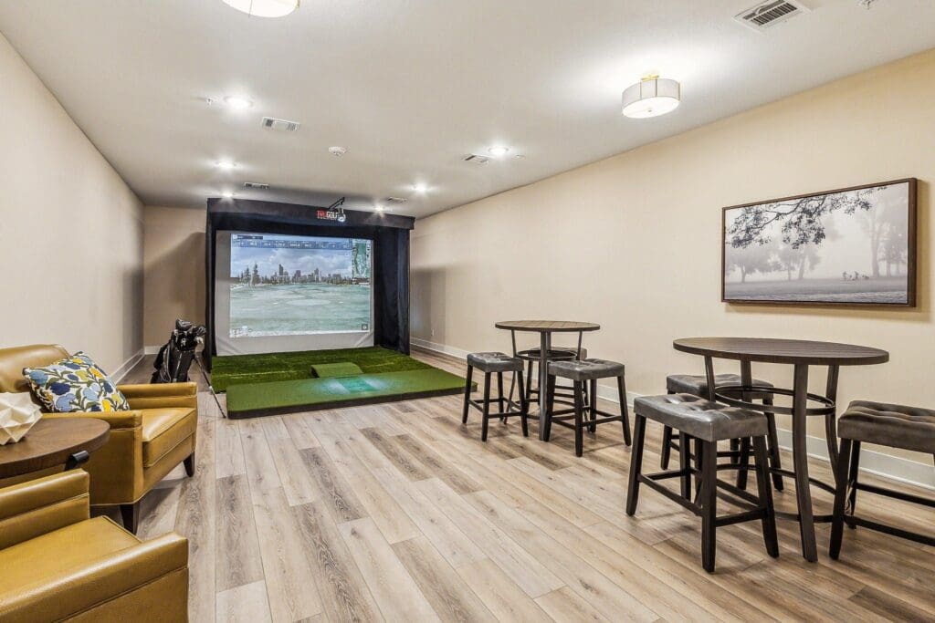Social room and golf simulator at The Lakes at Woodhaven Village, a retirement community near Houston.