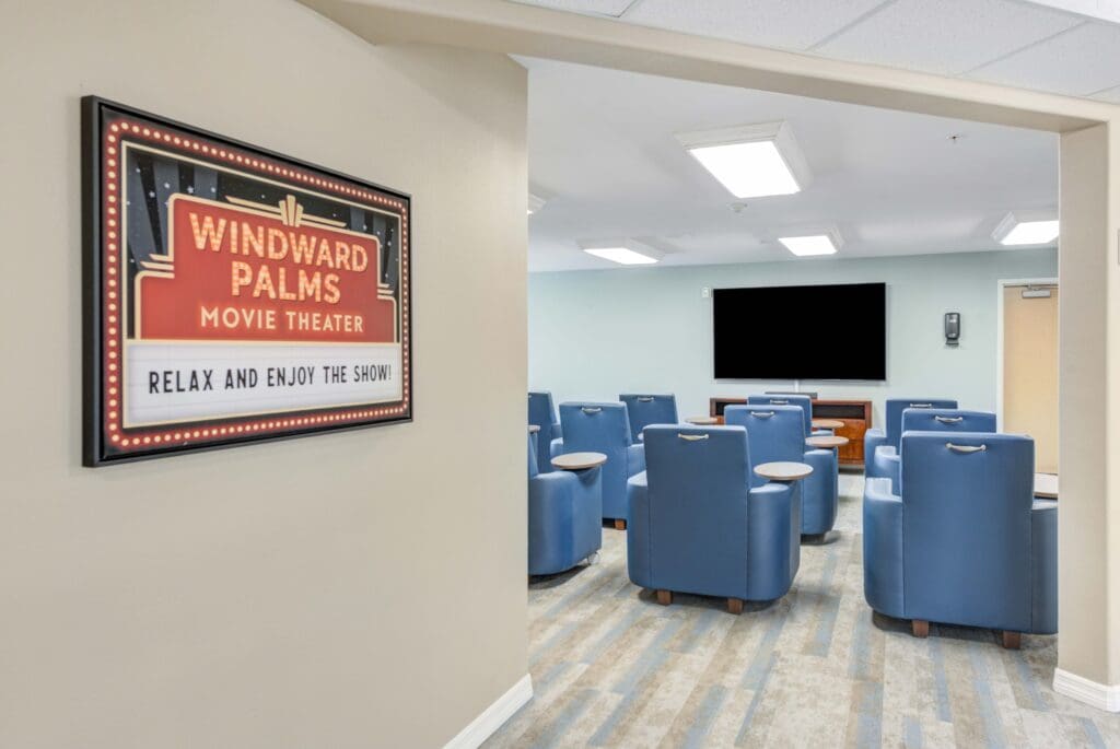 - Grace Management Interior shot of Windward Palms movie theater room. Comfortable blue chairs are lined up in front of a big television at Windward Palms, a premier senior living community near Boca Raton.