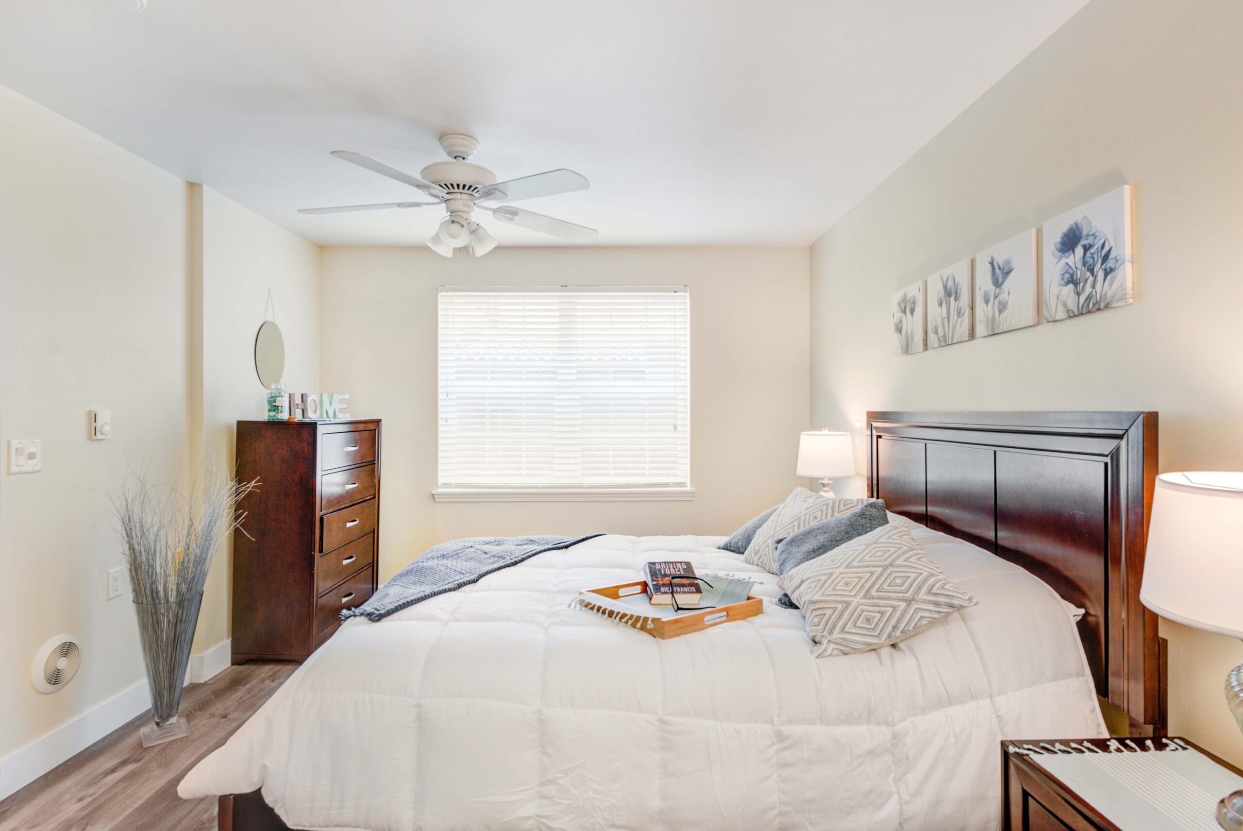 - Grace Management Interior shot of a resident's bedroom with comfortable furniture and big, bright windows at Windward Palms, a premier senior living community near Boca Raton.