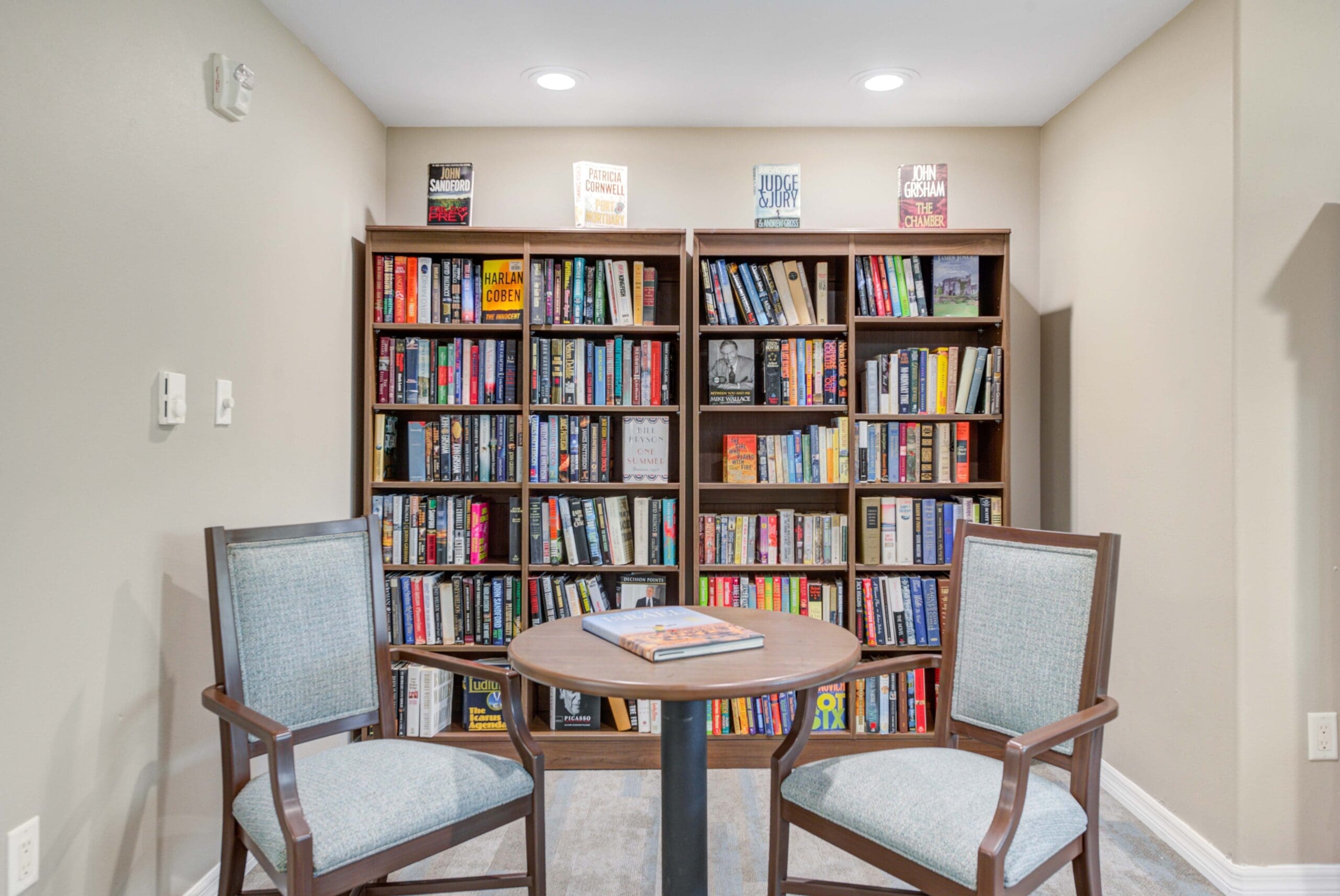 Interior shot of a full, colorful library with comfortable seating at Windward Palms, a premier senior living community near Boynton Beach.