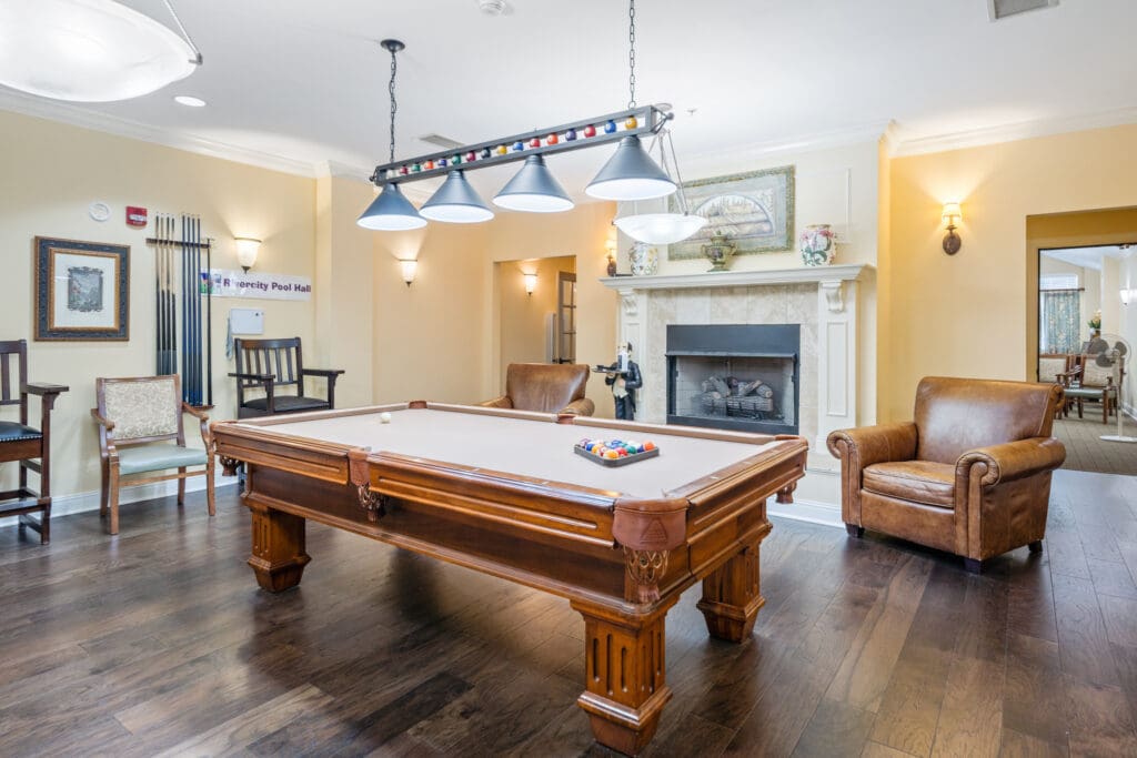 - Grace Management Interior image of the billiards room with a large pool table at Town Village Audubon Park.