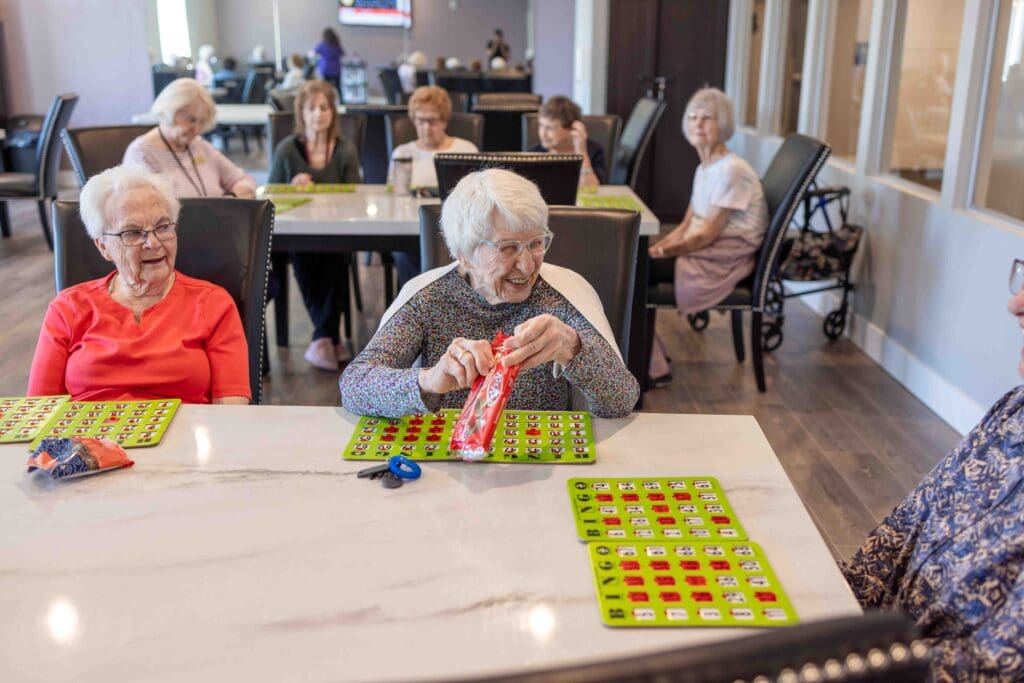 Smiling residents enjoying a game of bingo at The Pointe at Meridian, an excellent option for senior living.