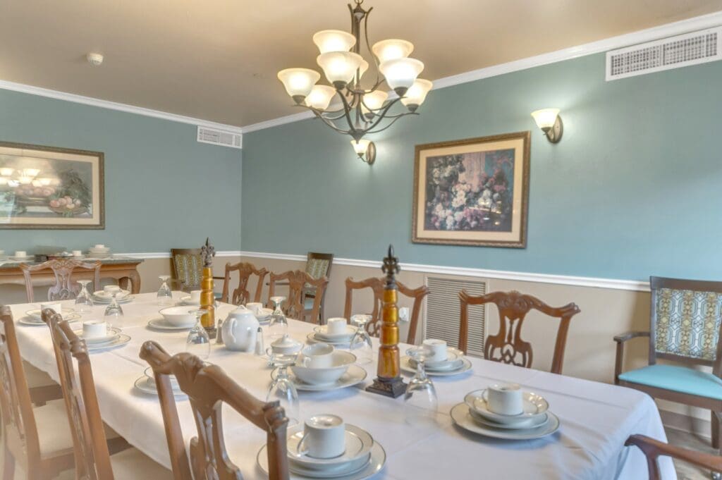 A long, formally set dining table in the private dining room at Collier Park, a senior living community near Orange, Texas.